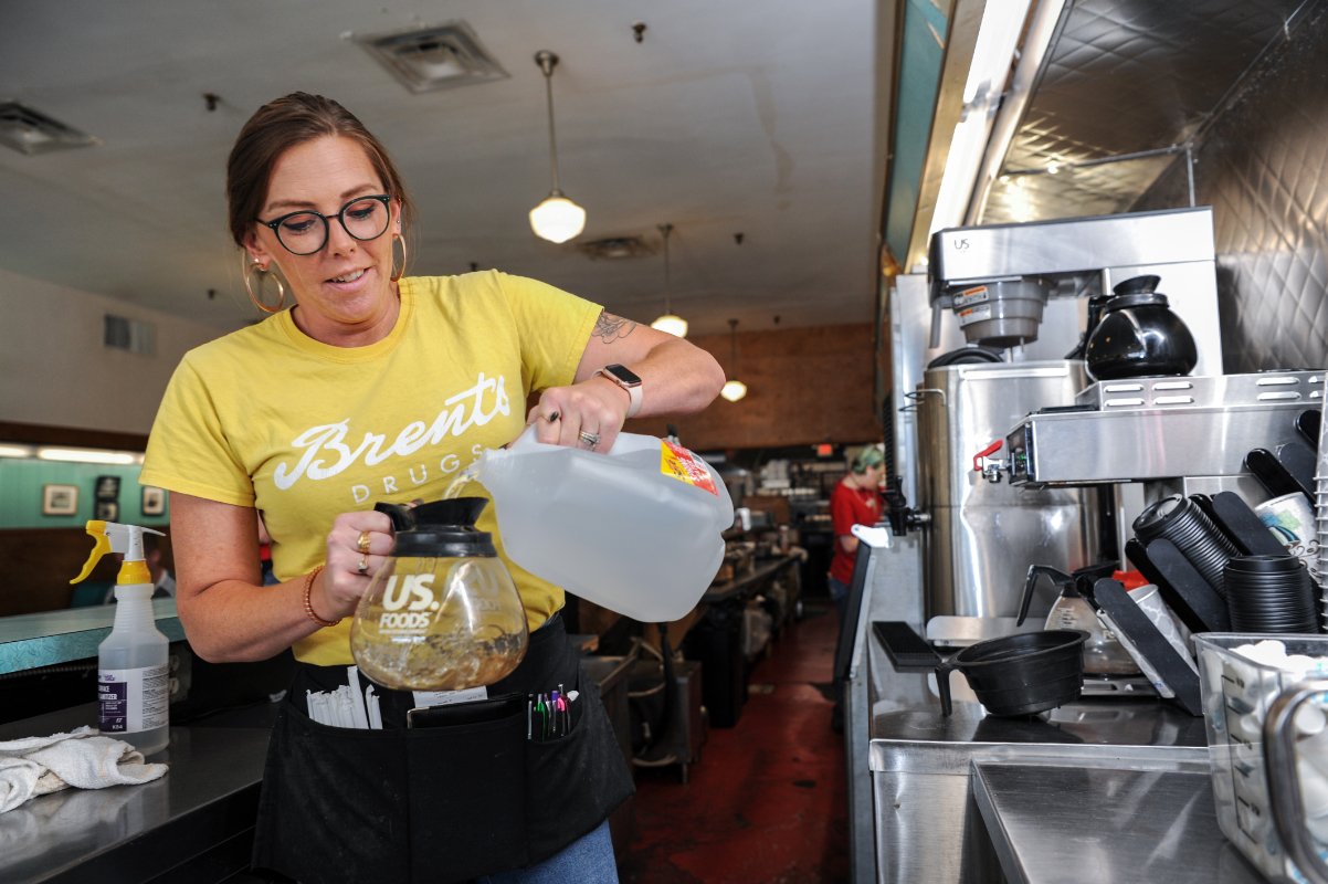 Brent's Drugs manager Sarah Donald pours bottled water into a coffee pot during the September 2022 water crisis. (Photo © Rory Doyle)